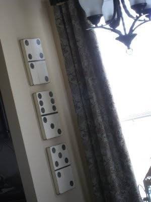 Three white dominoes on a beige counter.