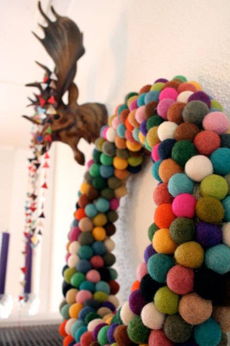 Colorful balloon decorations hang on a wall.