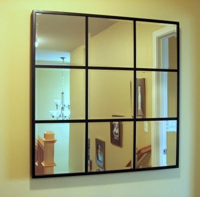 A mirror is divided into nine panes by thin wooden slats.