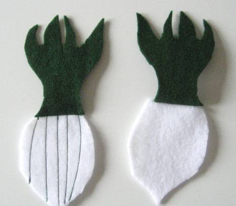 White felt is used to create an onion with strips sewn through it and a green top for the greens