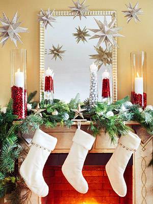 A fireplace with white stockings and red candles on top.