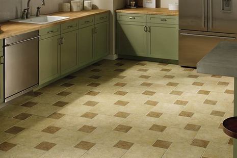 A kitchen with olive cabinets and a tan and brown checkered floor.