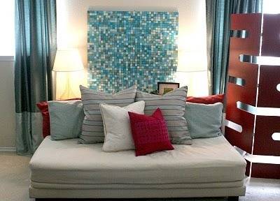 Day bed with lots of throw pillows on it in shades of blue, white, grey, and red.