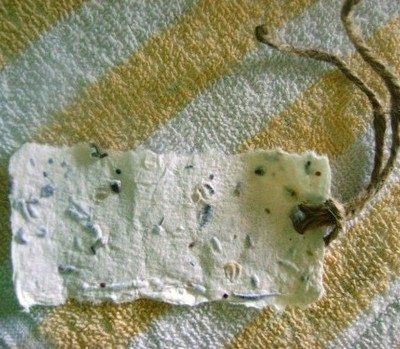 A yellow and white piece of fabric has a white tag laying on it.