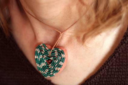 A green jewelry made out of dental floss worn around neck