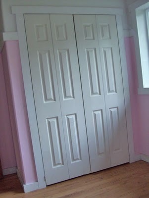Two doors stand in a pink room.