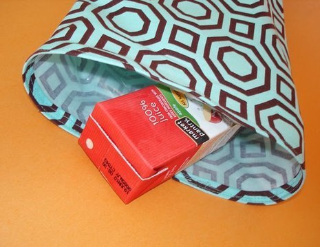 A juice box is sliding out of a bag.