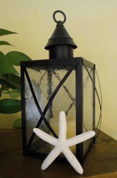 Black lamp lantern decorated with white starfish.