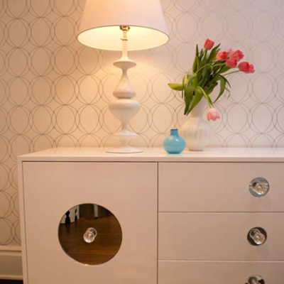 A white cabinet with a lamp on top of it.