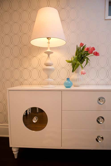 A white cabinet with a lamp on top of it.