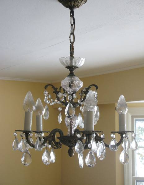 Five candle like light fixtures on a crystal chandelier