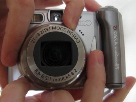 A person holding a Canon digital camera