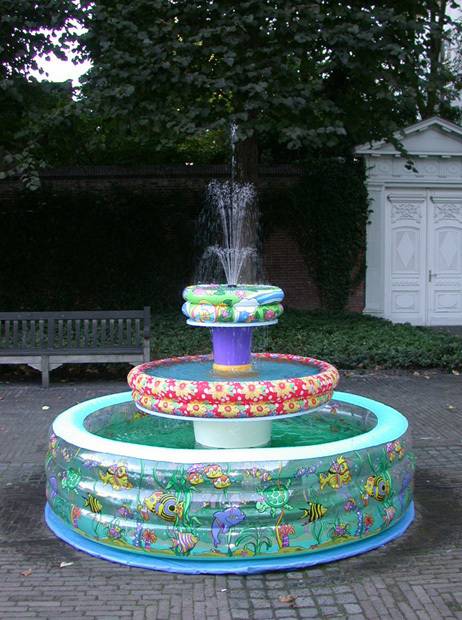 Water sprays out of a fountain made out of kiddie pools.