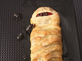 A turnover dessert has fake bugs crawling on it.
