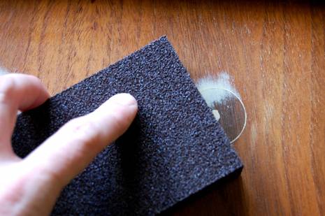 Amen sandpapering a wood filler hole.