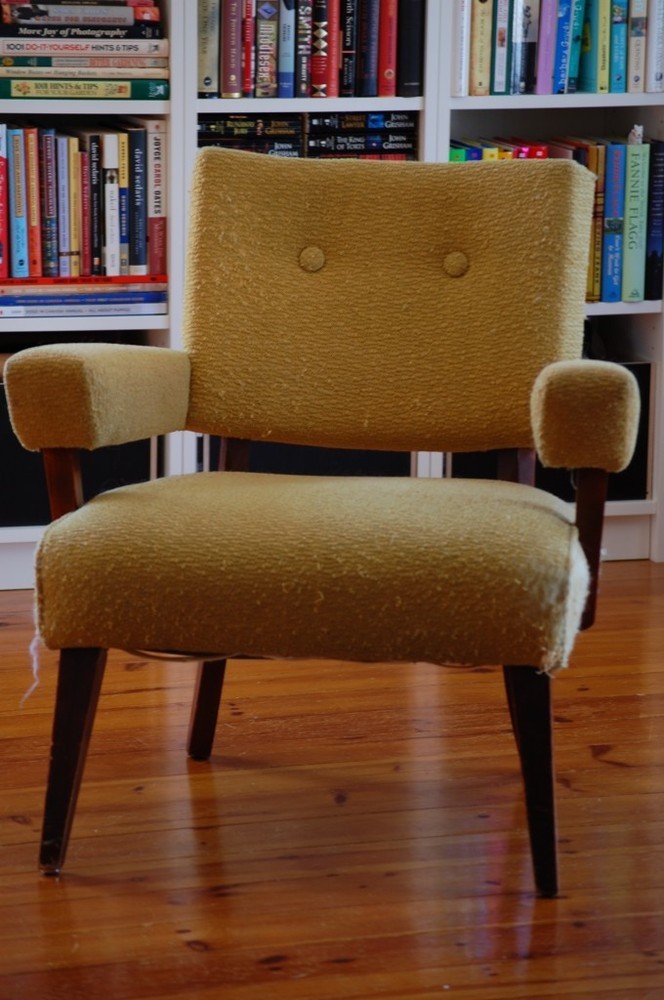 Brown color cushion chair in front of the bookshelf.