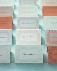 Several rows of neatly arranged place cards inscribed with different names and in various colors.