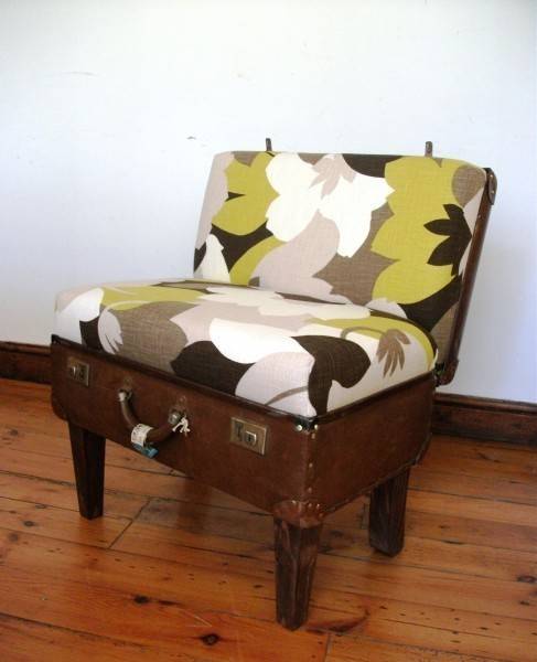 Upholstered cushion with a floral pattern sitting in a suitcase that is being used as a chair.