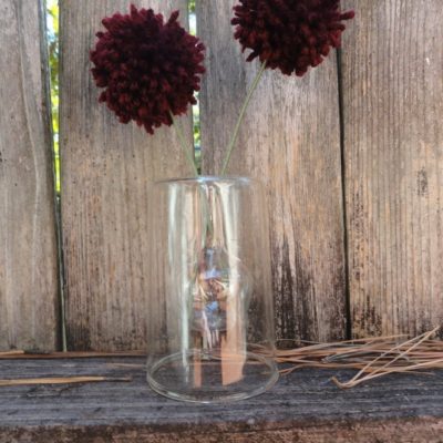 Maroon color yarn flowers on glass in the garden.