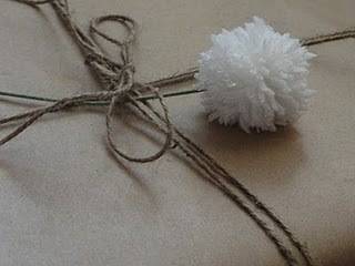 A white pom pom next to a rope tied item