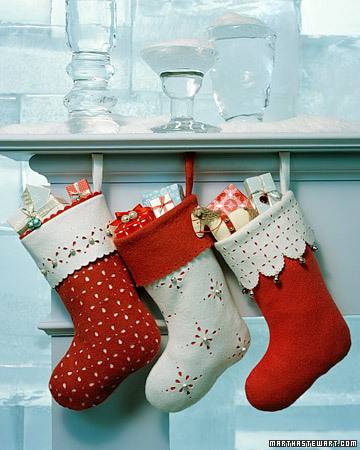 Stockings full of presents hanging below a shelf.