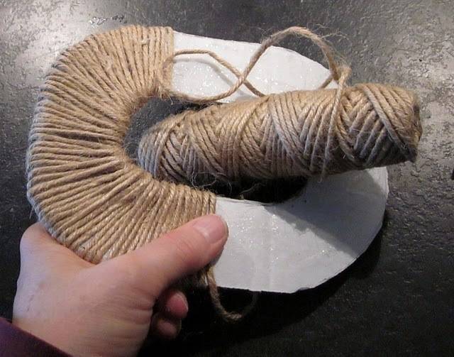 A hand holding a twine wrapped white item