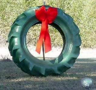 A large automobile tire with a red bow placed at the top to make it look like a Christmas wreath.