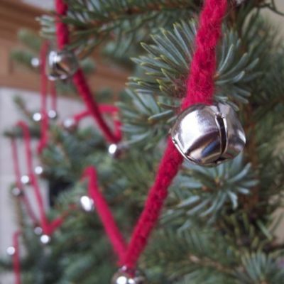 A jingle bell hung off a Christmas tree.