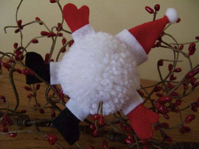 A white puffball is made into a craft Santa.