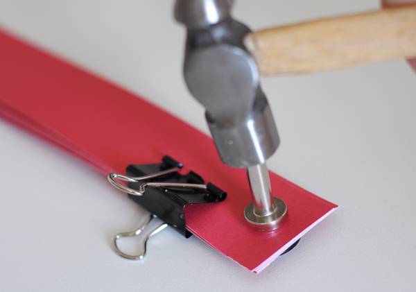 use a riveting tool to join the pieces of paper together