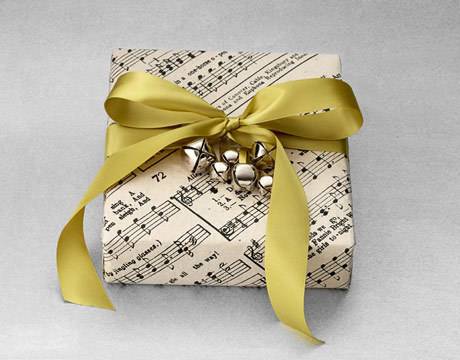 A present wrapped in sheet music wrapping paper and a golden bow.
