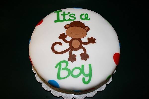 White color round cake with monkey drawing and text on top.