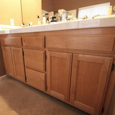 A knee high shot of an oak bathroom vanity cabinet.