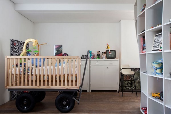 A crib on black wheels sits in a laundry room