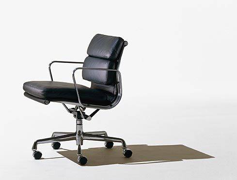 A black office chair has silver arms, a short back, and an extended seat