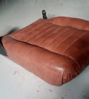 Red fabric covers a Porsche car seat that is out of the car.