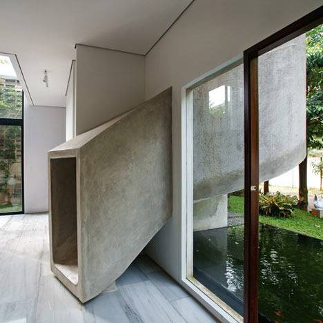 A concrete slide partly outside spills into the interior of a modern home.