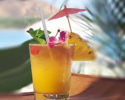 An orange tropical drink with a pink umbrella hanging out of it.