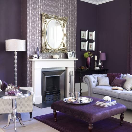 Purple color living room with fireplace, couch, purple cushion table, wall mirror, and table lamp.