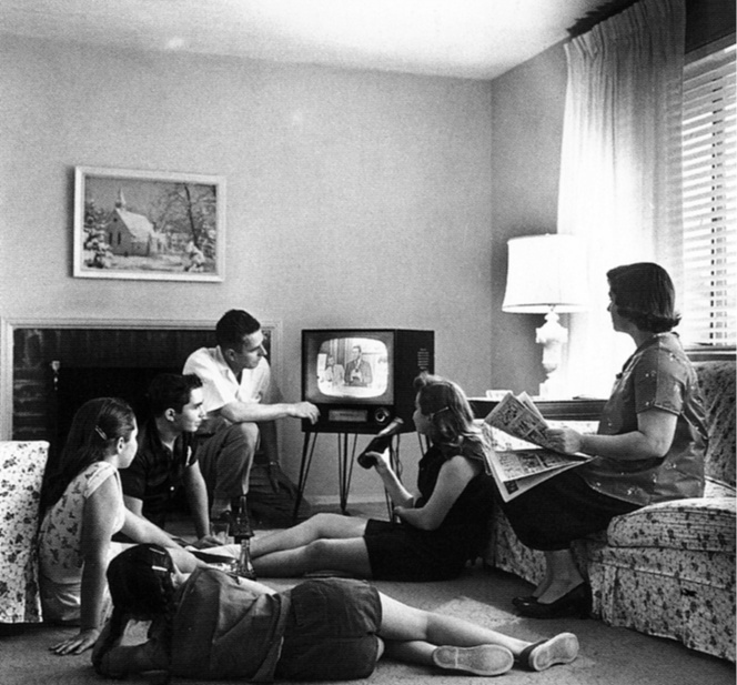 Family members are watching an old TV while sitting in the living room.