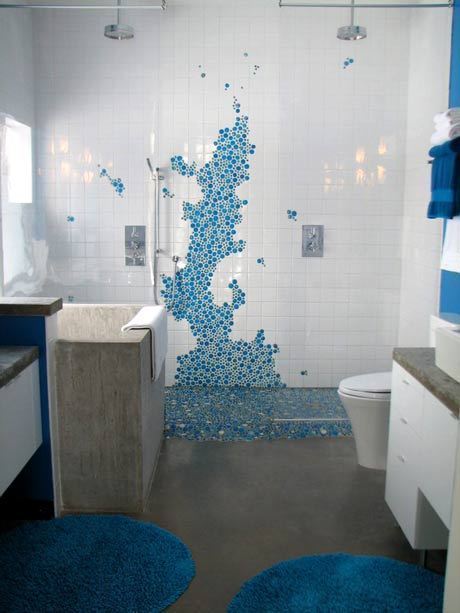 Bathroom having white and blue tiles on the wall and blue rug on the floor.