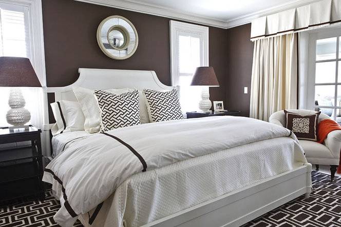 Chocolate color bedroom with white bed and bedside tables with lamps on both sides.