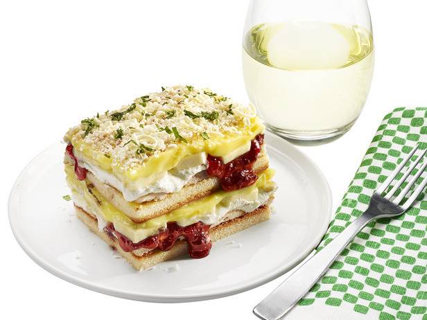 Bread sandwich on plate with water glass and fork on table mat.