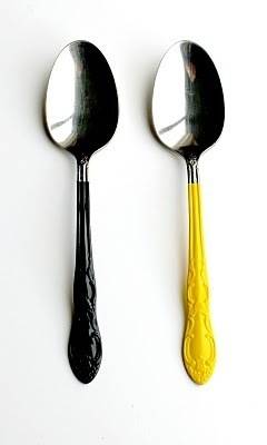 Two spoons, one with a black handle and the other with a  yellow handle.