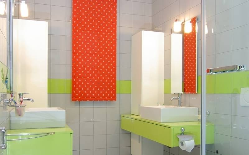 Small-bathroom-with-orange-towel-green-drawers-white-tiles-and-white-sink
