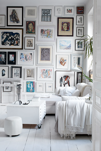Photo gallery walls with white cushions aside.