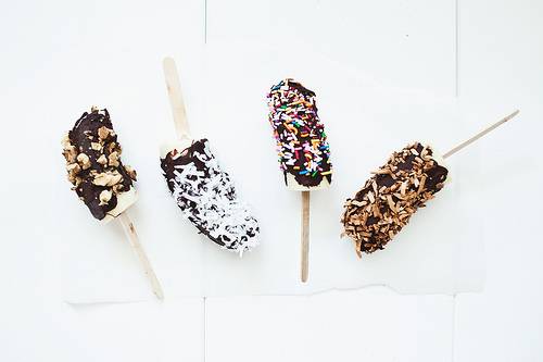 Chocolate ice cream sticks with colorful toppings.