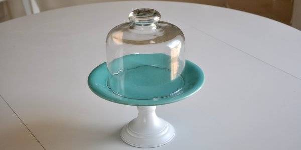 Glass cake stand above the white table.
