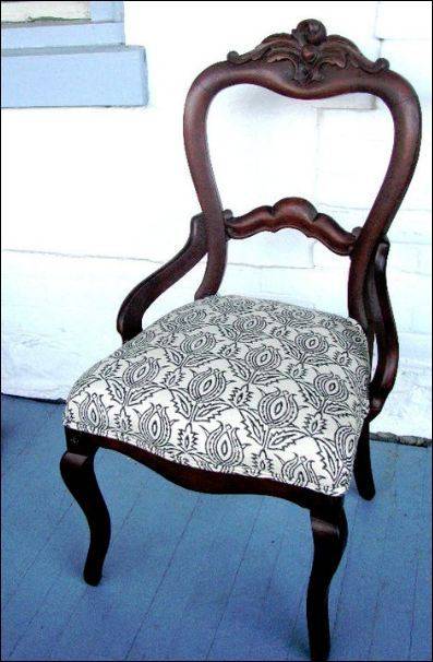 Designer wooden chair with cushion.