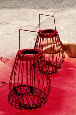 Two lamp shades with hangers colored with red spray.